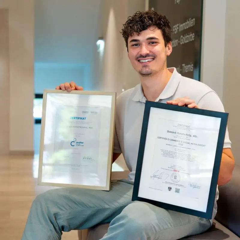 Dominik Pototschnig holding his framed certificates in digital consulting and e-commerce
