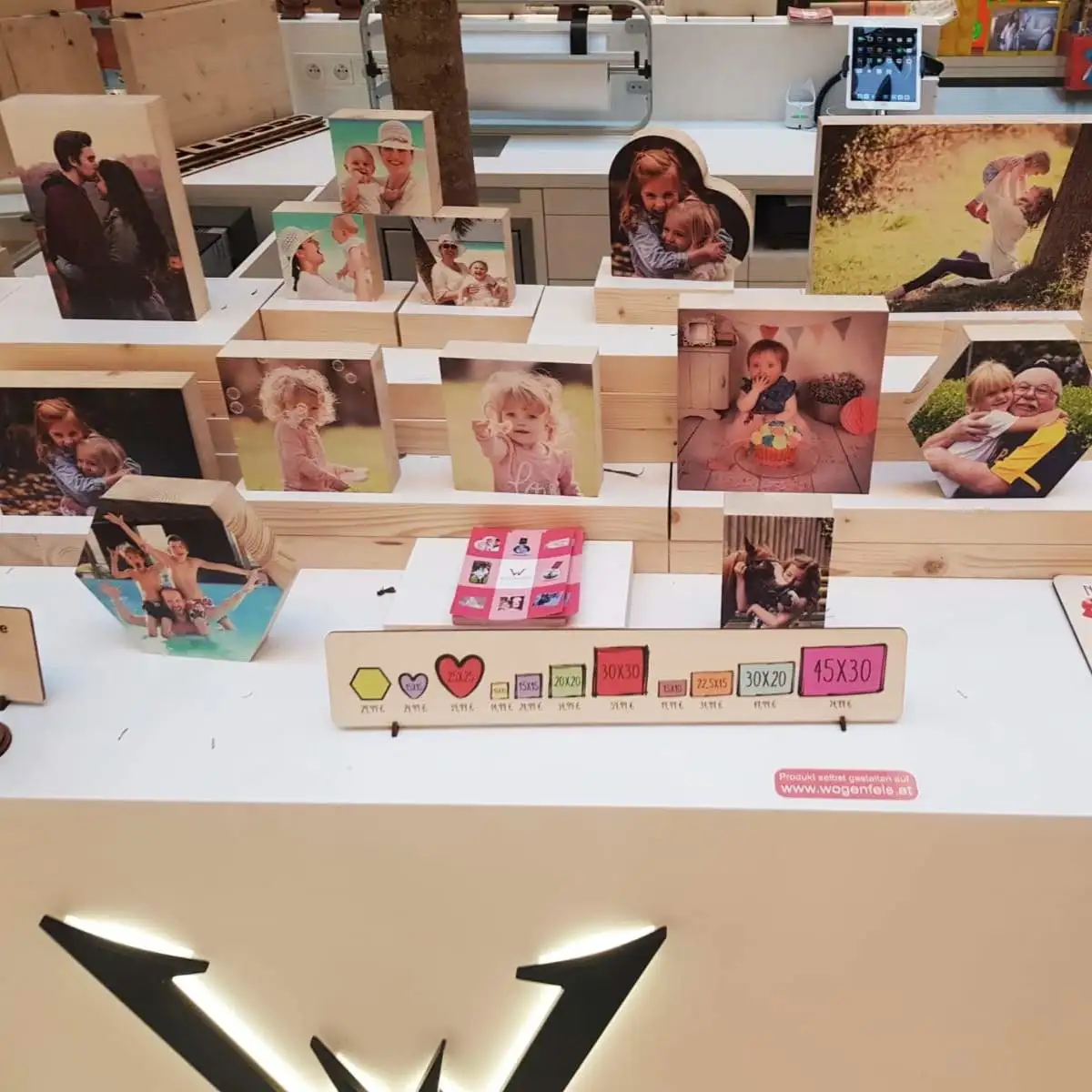Pop-up store display of personalised photo engravings on wood in a range of formats